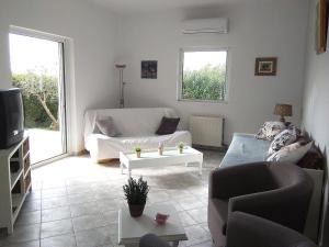 a living room with a couch and a tv at appartement lena in Messini