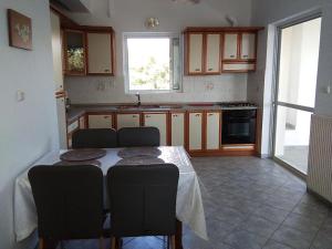 a kitchen with a table and chairs and a kitchen with a window at appartement lena in Messini