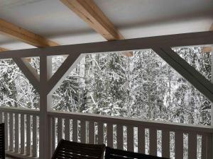 a screened in porch with a bench and snow covered trees at Idyllic house in beautiful area in Saxby