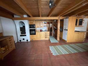 a large kitchen with wooden cabinets and appliances at Idyllic house in beautiful area in Saxby +10 photos