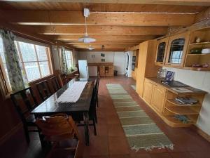 a dining room with a long table and a kitchen at Idyllic house in beautiful area in Saxby