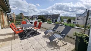 a patio with chairs and a table on a balcony at Moderne Wohnung Cathy in Bad Iburg