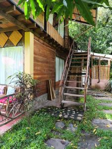Bella Victoria Ecolodge في Santa María: منزل خشبي مع درج خشبي يؤدي إلى الشرفة +70 صورة