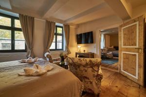 a bedroom with a bed with a chair and a window at Schinkel Ferienunterkünfte UNESCO Welterbestadt Quedlinburg, beste Lage inklusive Parkplatz & Kurtaxe in Quedlinburg