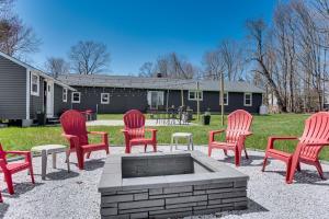 a group of red chairs sitting around a fire pit at Acres Away Spacious Maine Retreat with Bunkhouse in Eliot
