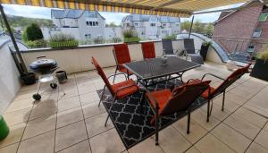 a patio with a table and chairs on a balcony at Moderne Wohnung Cathy in Bad Iburg