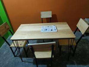 a wooden table and chairs with a newspaper on it at Hotel Baishnav, Mugling in Upardāng Garhi
