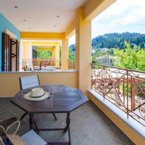a balcony with a table with a hat on it at EXELLENT GUEST VILLA PRESTIGE in Asprogerakata