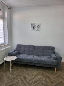 a living room with a blue couch and a table at Sehr gut gelegene Wohnung im Herzen Hannovers in Hannover +2 photos