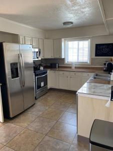 a kitchen with a stainless steel refrigerator and appliances at Vegas Oasis- Modern Getaway 5 mins from Strip in Las Vegas