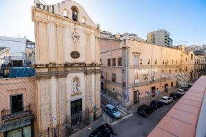 un vecchio edificio con auto parcheggiate in strada di Casa Vacanze Francy House a Termini Imerese