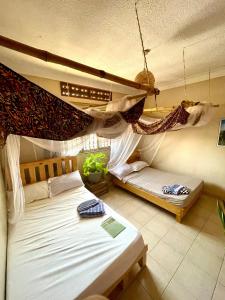 1 dormitorio con 2 camas y hamaca en Entire Artist Oasis home, en Kampala