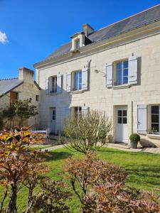 a large white brick house with a yard at Au pied du Lavoir chambre Germaine in Grézillé