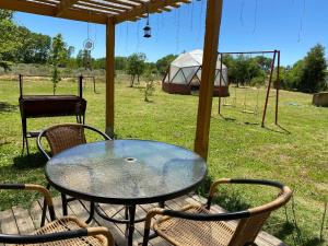 a table and chairs with a tent in a field at Casa comoda in Salto del Laja +5 photos