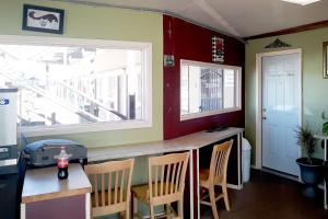 a kitchen with a bar with chairs and a window at OYO Hotel Kings at Clovis in Clovis