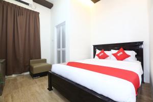 a bedroom with a large bed with red pillows at Hotel O Ady Hotel in Kuala Terengganu