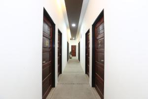 a hallway with dark wood doors and a white wall at Hotel O Ady Hotel in Kuala Terengganu
