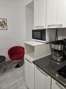 a kitchen with a microwave and a red chair at Sweet room in Bucharest