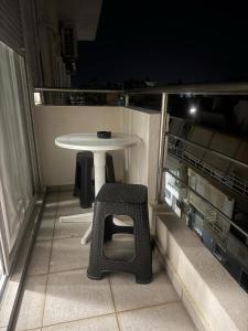 a small table and chair on a balcony at night at Blue Maizon in Heraklio Town