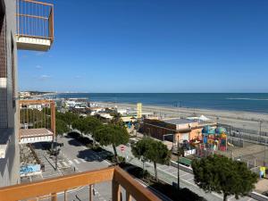 a view of a beach with a playground and the ocean at La Corte Dei Mari Acquamarina in Cesenatico