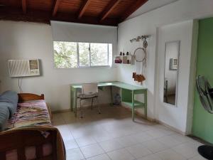 Zimmer mit einem grünen Schreibtisch und einem Fenster in der Unterkunft Departamento amplio y equipado en Santiago del Estero in Santiago del Estero