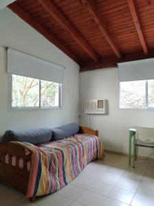 ein Schlafzimmer mit einem Bett und zwei Fenstern in der Unterkunft Departamento amplio y equipado en Santiago del Estero in Santiago del Estero