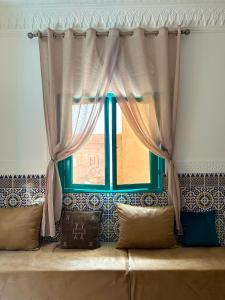 a window in a room with a couch in front at Dar Al-Andalus in Tamraght Ouzdar +59 photos