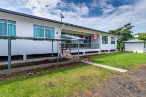 a white building with a lawn in front of it at Hotel O Eagle Wood Garden in Membakut +58 photos