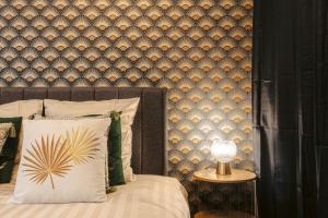 a bedroom with a bed with a wall at Gatsby - Élégant, Central, Fibre, Tv 4K, Netflix, Literie Confortable in La Rochelle