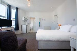 a hotel room with a large white bed and a television at Pier Hotel Clacton on Sea By OYO in Clacton-on-Sea