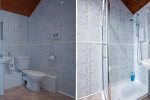 a bathroom with a shower and a toilet and a sink at Pier Hotel Clacton on Sea By OYO in Clacton-on-Sea +72 photos