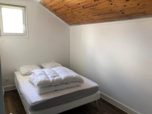 a bedroom with a bed with white sheets and a window at Les Coteaux in Gérardmer