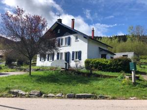 a white house sitting on the side of a road at Les Coteaux in Gérardmer