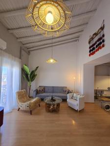 a living room with a couch and a chandelier at Urban Loft - La Conce in Cáceres