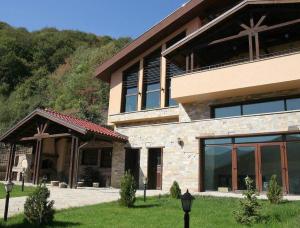 a large building with glass windows in a yard at Къща за гости Seltse Villa in Seltse