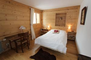 a bedroom with a bed and a table and a desk at La Malandre in Chateau-d'Oex