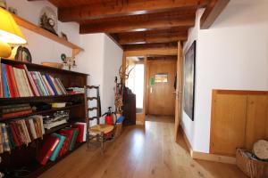 a living room with bookshelves and a hallway with a door at La Malandre in Chateau-d'Oex