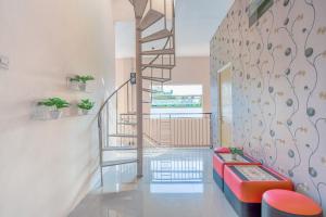 a living room with a staircase and a red bench at OYO 3434 Penginapan Keluarga Syariah in Lamongan
