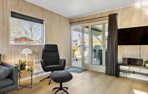 a living room with a chair and a television at 3 Bedroom Lovely Home In Sydals in Neder Lysabild