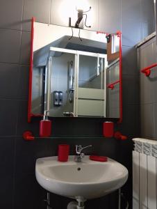 une salle de bain avec un lavabo et un miroir dans l'établissement Ortacolorhome-GreyHome Boleto, à Madonna del Sasso 17 autres photos