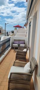 a balcony with two benches on a building at FM Central Vila Apartment in Carvoeiro