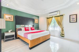 a bedroom with a large bed with red pillows at OYO 926 Sydney Resort in Ban Don Pho