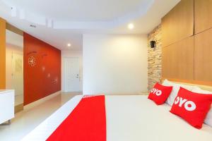 a bedroom with a large white bed with red pillows at OYO 926 Sydney Resort in Ban Don Pho
