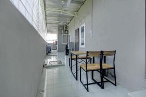 a hallway with a table and chairs in a building at OYO Life 3415 Penginapan Wimane in Sukarami +26 photos