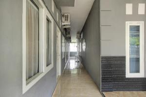 an empty hallway of a building with windows at OYO Life 3415 Penginapan Wimane in Sukarami