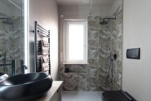 a bathroom with a black sink and a shower at Jungle Apartment in Schio