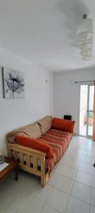 a couch in a white room with a red bed at Precioso departamento en Paraná. Zona Centro in Paraná