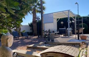 patio z krzesłami, stołem i ławką w obiekcie Vacaciones La Marina Costa Blanca w mieście La Marina