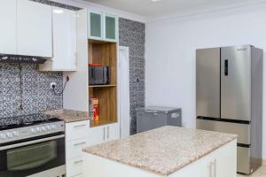 a kitchen with white cabinets and a stainless steel refrigerator at Casa Eko in Lekki
