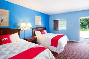 a hotel room with two beds and blue walls at BlueJay Motel - Salem - Roanoke I-81 in Salem